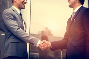 A Capital Rivers commercial real estate broker shaking hands with a client, both engaged in a discussion about tenant representation, symbolizing the trust and partnership in the commercial property industry.