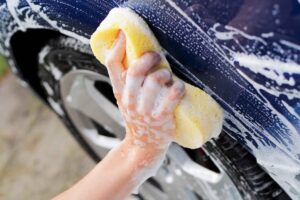 Image of a person washing a car by hand, symbolizing the humble beginnings of Danny Arroyo and Kasra Erfanian. From their days at McDonald’s to their recent commercial real estate acquisition in Rancho Cordova, their enduring partnership is a testament to entrepreneurial spirit celebrated by Capital Rivers Commercial.
