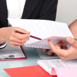 A landlord and tenant discussing or reviewing paperwork, illustrating the tenant's role in confirming lease details for the estopple certificate.