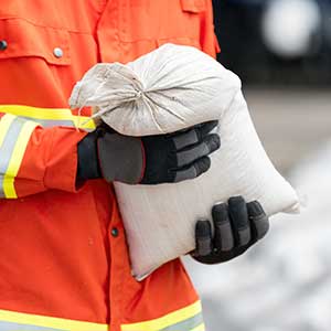 Worker placing sandbags while preparing your property for the winter season