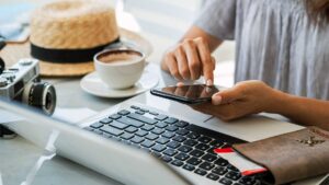 Traveler planning a trip on mobile device and laptop, representing AI search optimization for tourism and AI-powered travel planning