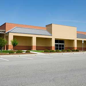 Vacant commercial building with parking lot illustrating commercial property leasing and available space.