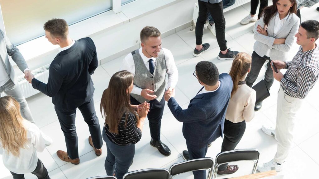 Attendees networking and shaking hands at a National PACE Association conference.